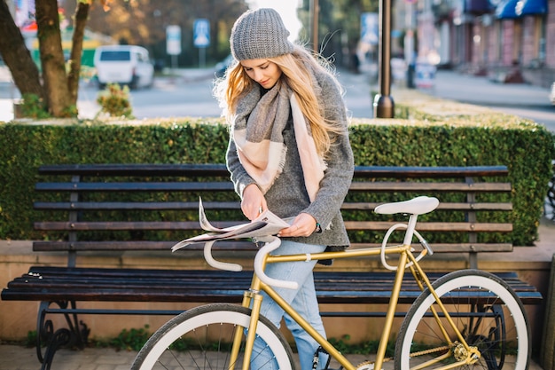 Femme, à, bicyclette, searcing, information, dans, journal