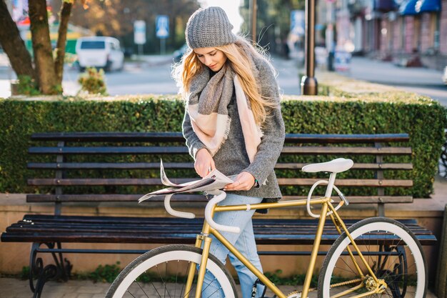 Femme, à, bicyclette, searcing, information, dans, journal