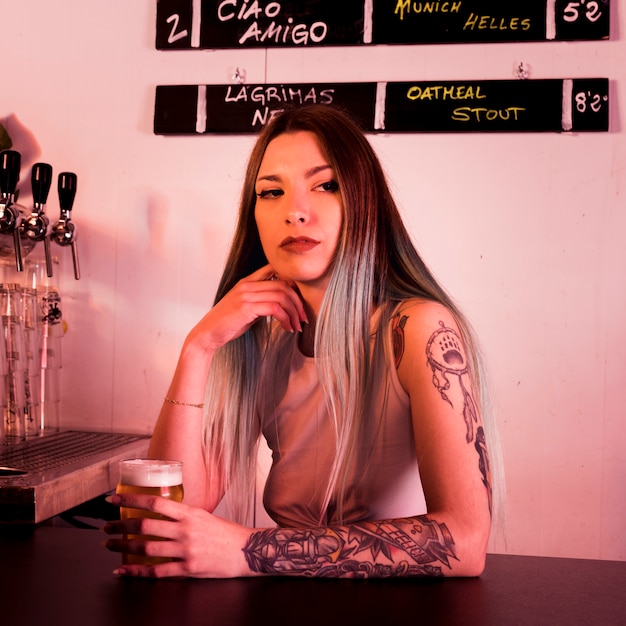 Femme avec de la bière artisanale au bar