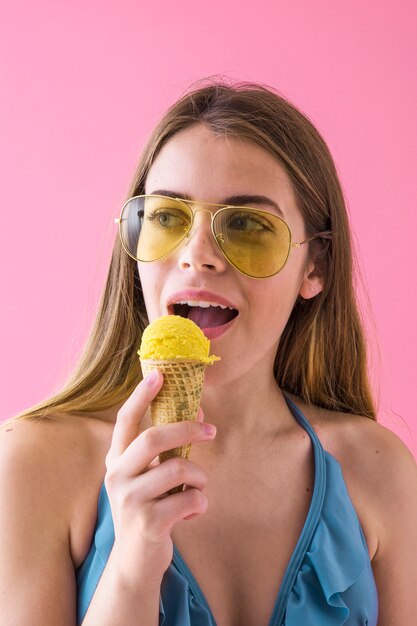 Femme en bikini avec crème glacée et lunettes de soleil