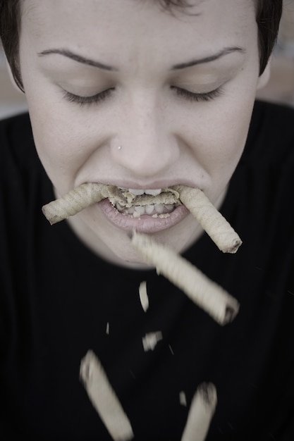 Photo gratuite femme avec des biscuits dans la bouche