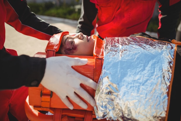 Photo gratuite femme blessée traitée par un ambulancier