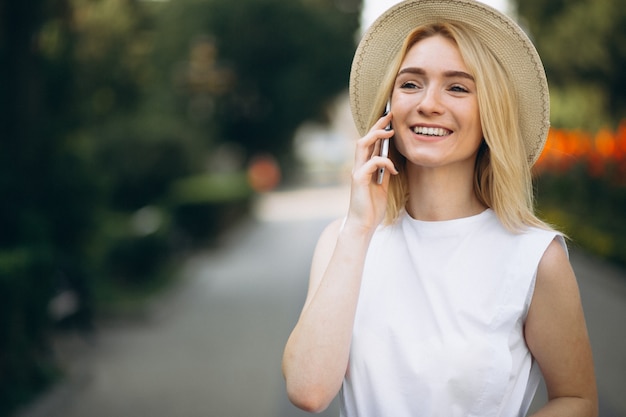 Femme blonde au chapeau à l&#39;aide de téléphone