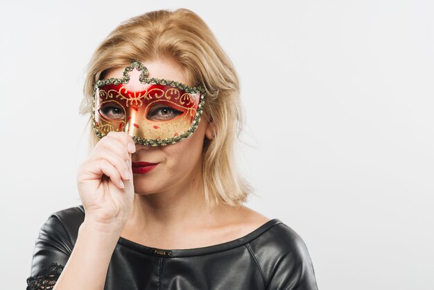 Femme blonde au masque de carnaval rouge