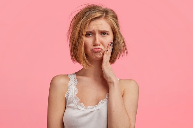 Femme blonde aux cheveux en désordre portant haut