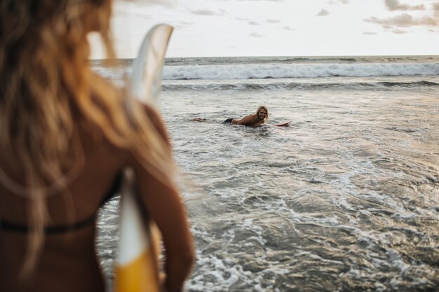 Femme blonde bouclée fait du surf