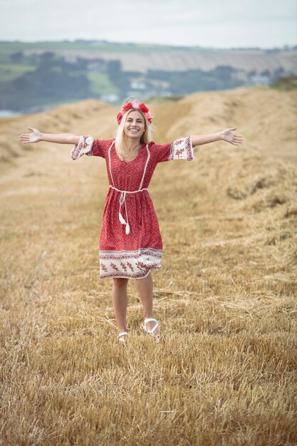 Femme blonde insouciante, debout dans le champ