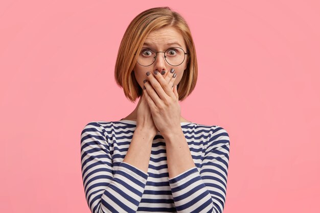 Femme blonde à lunettes rondes et chemisier rayé