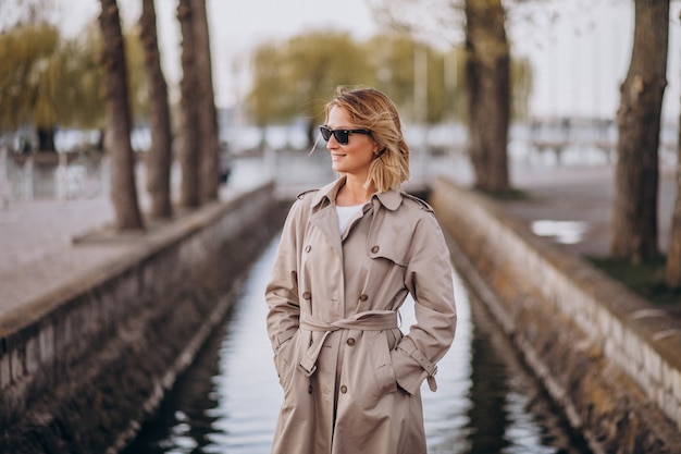 Femme blonde en manteau dehors dans le parc