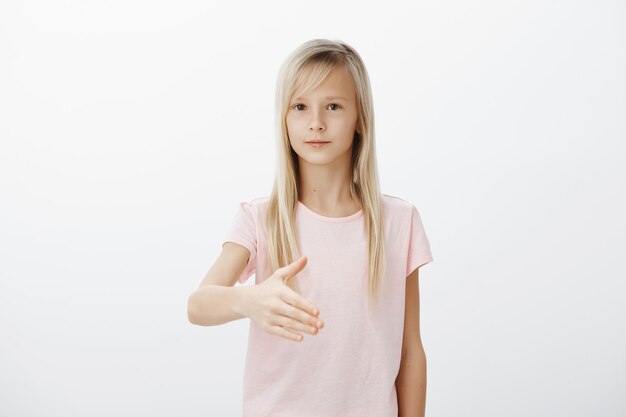 Femme blonde mignonne sérieuse tendre la main pour la poignée de main, se présenter poliment