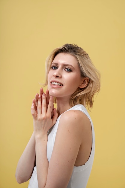 Femme blonde à la peau brillante posant