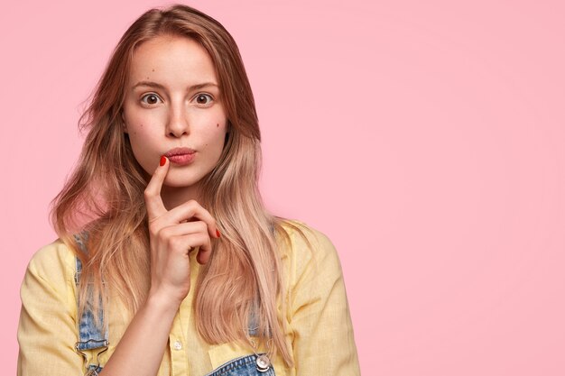 Femme blonde portant une salopette en denim