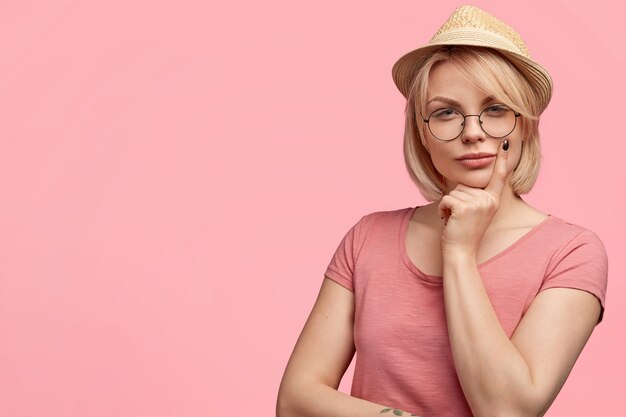 Femme blonde portant un T-shirt et un chapeau rose