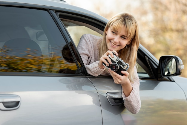 Photo gratuite femme blonde prenant des photos de voiture