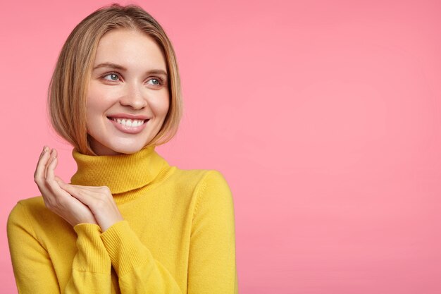 Femme blonde en pull à col roulé