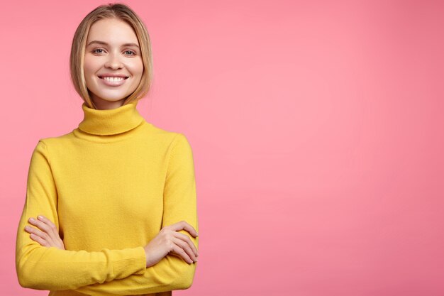 Femme blonde en pull à col roulé