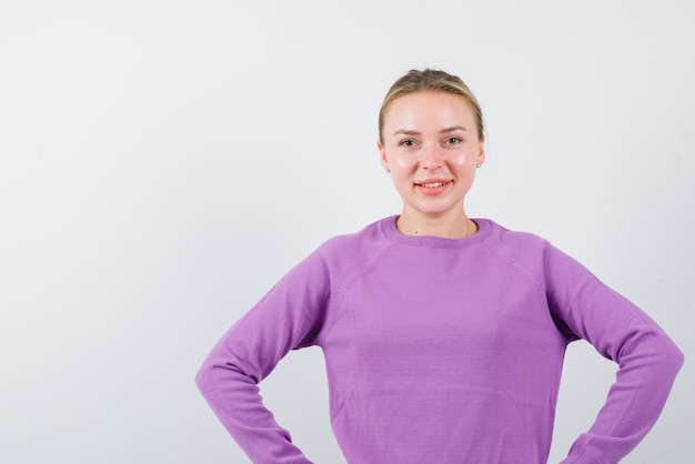 La femme blonde regarde la caméra sur fond blanc