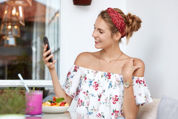 Femme blonde en robe à fleurs au café