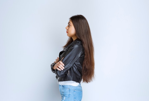 femme en blouson de cuir croisant les bras et donnant des poses professionnelles.