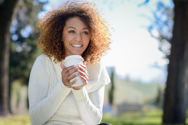 Femme de boire un café chaud en plein air