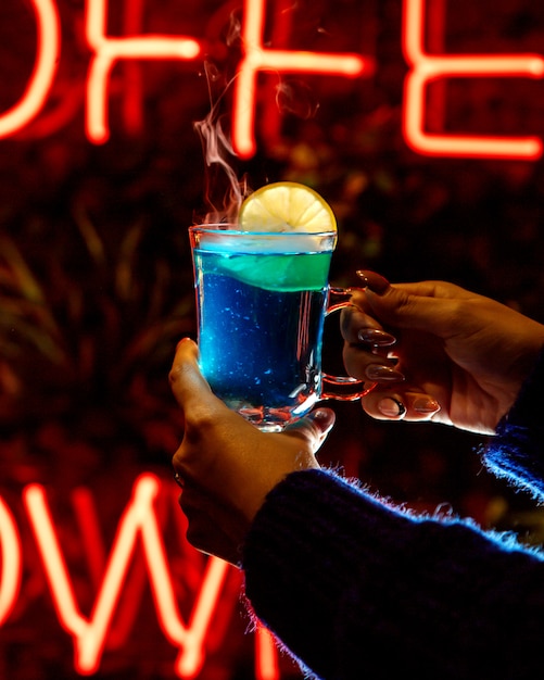 Femme avec une boisson bleue dans ses mains