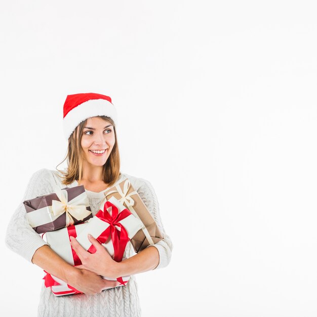 Femme en bonnet de noel avec coffrets cadeaux