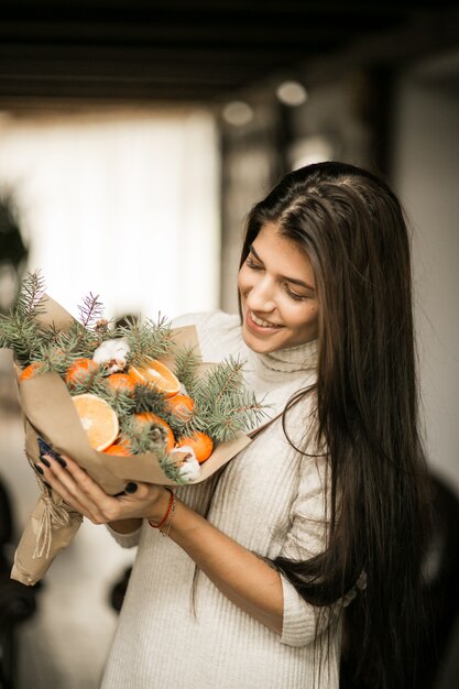 Femme avec un bouquet de fruits à Noël