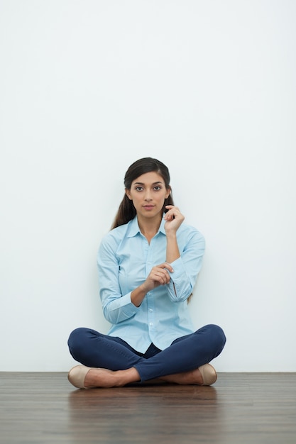 Femme boutonnage sur Cuff et assis sur le plancher