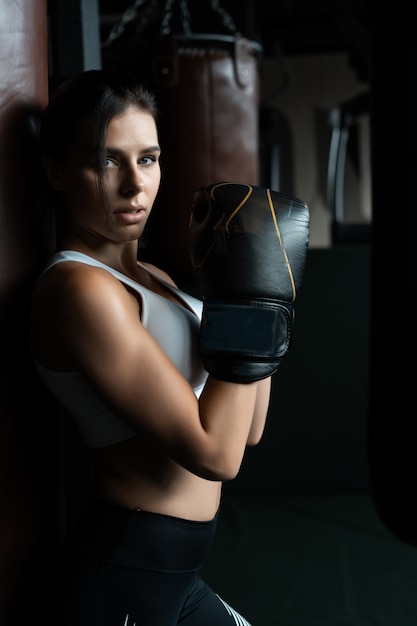 Femme de boxe posant avec sac de boxe. Concept de femme forte et indépendante