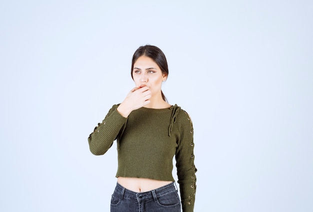 femme brune debout et pensant sur fond blanc.