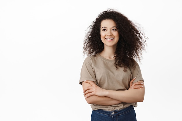 Femme brune frisée souriante sur blanc