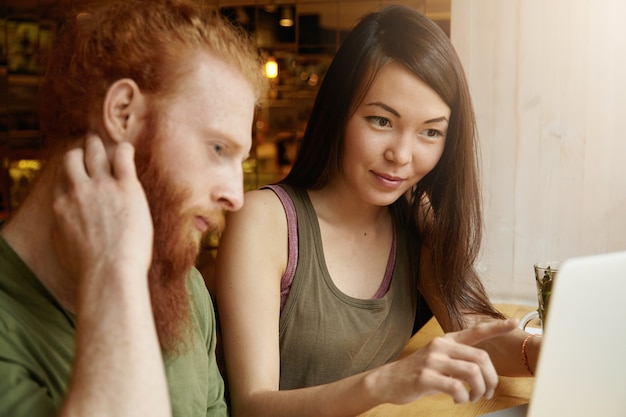 Femme brune et homme au gingembre assis dans un café