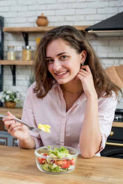 Femme brune mangeant une salade