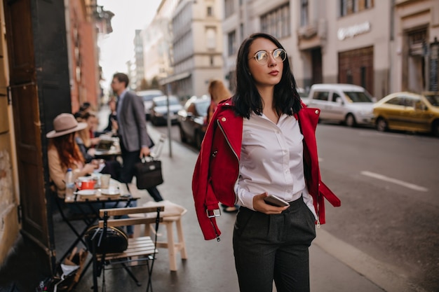 Femme brune à la mode en tenue de bureau, passer du temps, se promener dans la ville