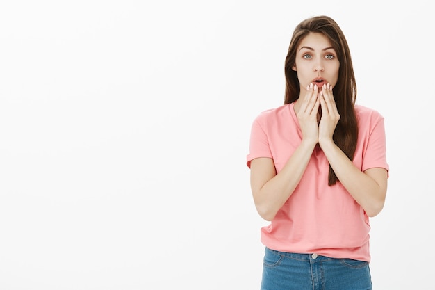 Femme brune nerveuse choquée qui pose en studio