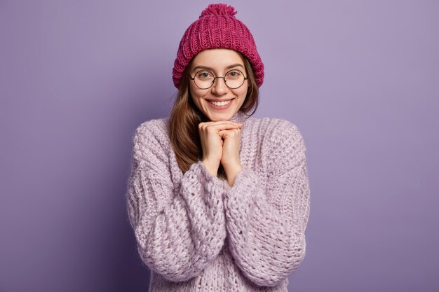 Femme brune portant un pull et un chapeau