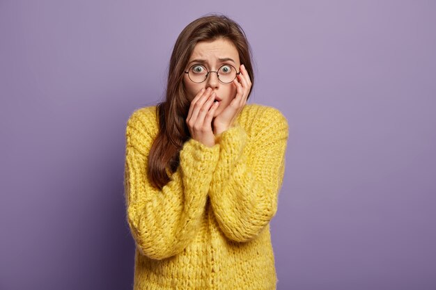 Femme brune portant un pull jaune