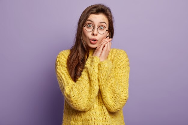 Femme brune portant un pull jaune