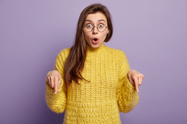 Femme brune portant un pull jaune