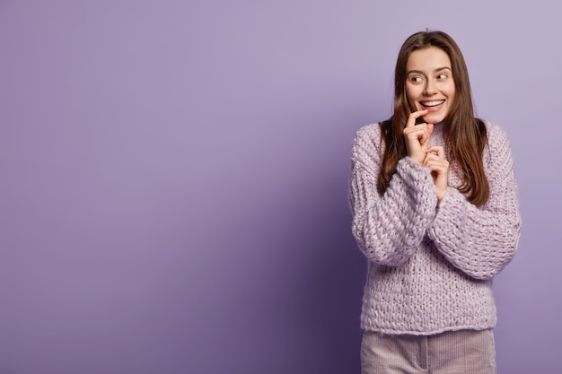 Femme brune portant un pull en tricot