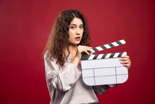 Femme brune posant avec clap.