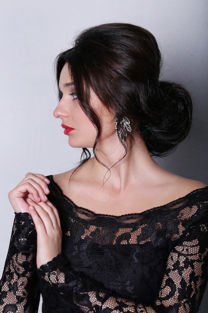 femme brune avec rouge à lèvres et robe noire