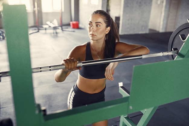 Femme brune de sport dans une formation sportswear dans une salle de sport