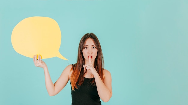 Photo gratuite femme avec bulle de dialogue montrant le geste de silence