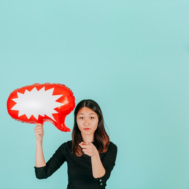 Femme avec bulle de dialogue pointant vers la caméra