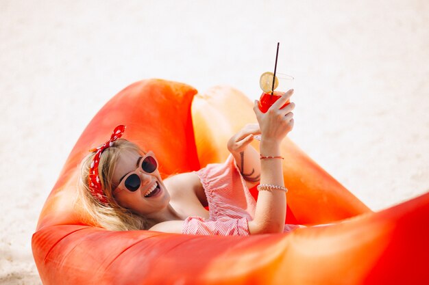 Femme buvant un cocktail à la plage