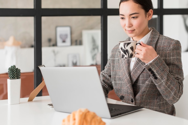 Femme buvant du café tout en travaillant