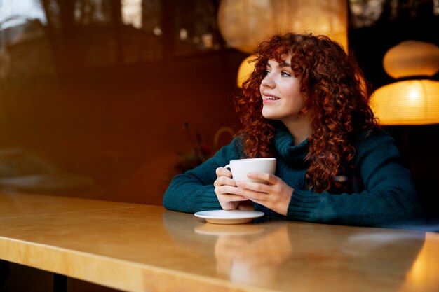 Femme buvant du chocolat chaud au café