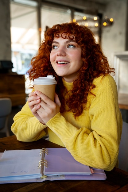 Photo gratuite femme buvant du chocolat chaud au café