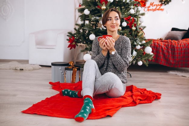 Femme buvant du thé le soir de Noël